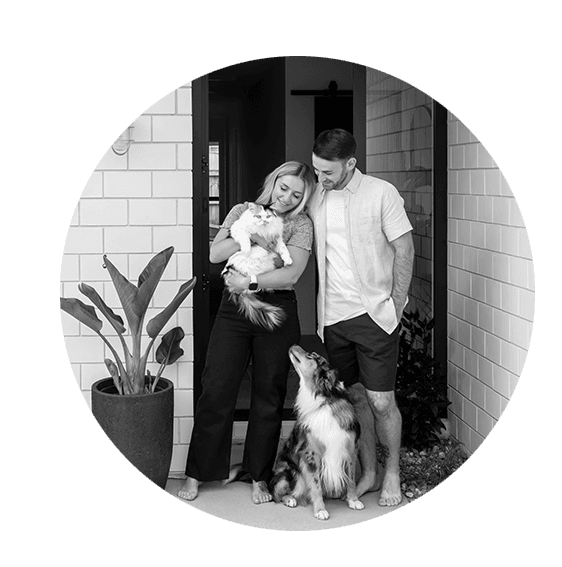 Young couple with their dog and cat in front of a Signature home