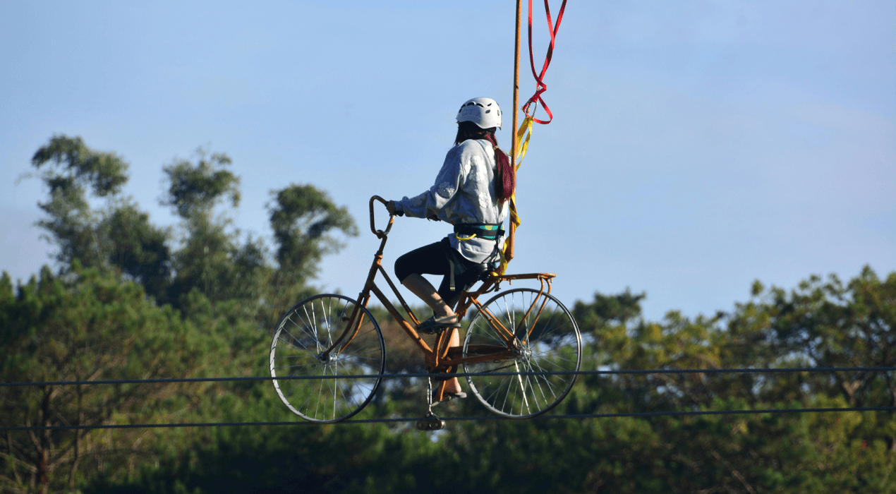 Person riding a bicycle along a tightrope