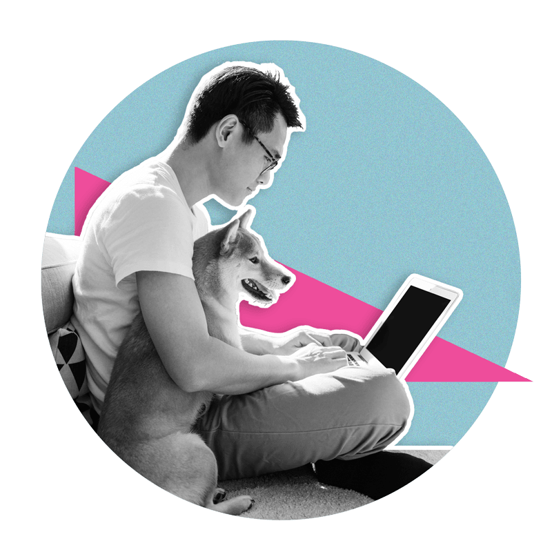 man sitting on couch with dog looking at laptop