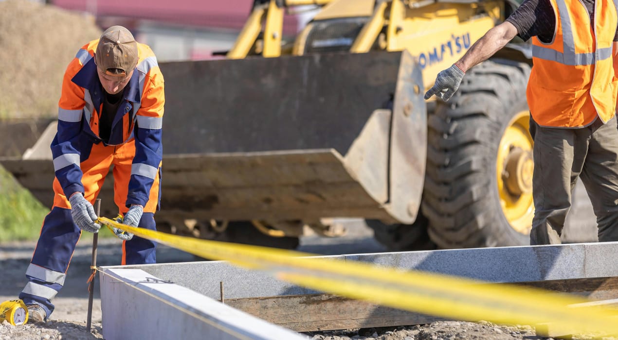 Construction worker measuring foundations on a building site
