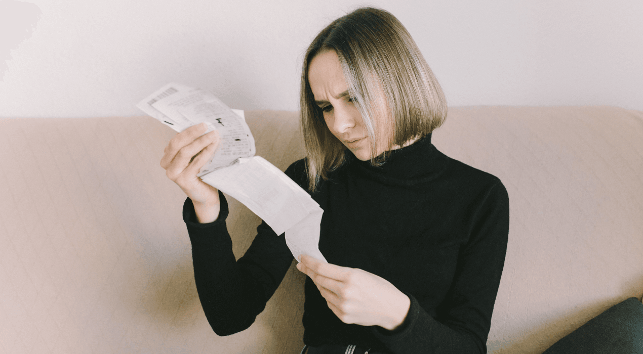 Woman dressed in black looking closely at a long receipt