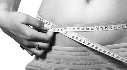 Fitness goals, measuring stomach with tape