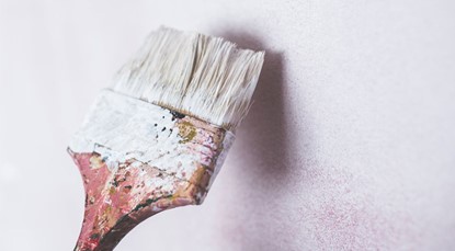 Paint brush with white paint, renovation