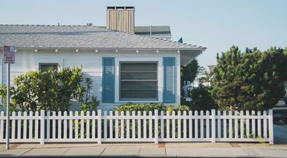 Weatherboard house, sitting behind white picket fence