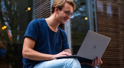 Young male investor looking at laptop