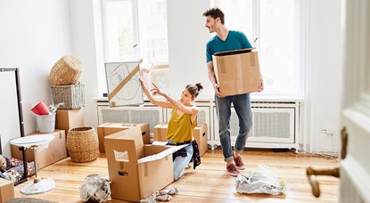 Young couple unpacking boxes in new home