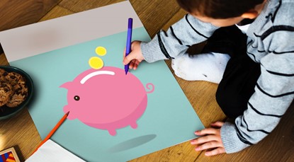 Child drawing on picture of piggy bank on a wooden floor