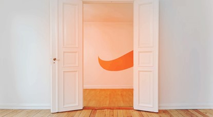 Wall with two white open doors, orange Squirrel tail on the wall