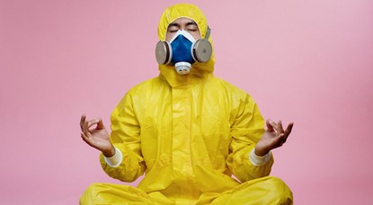 Man in yellow boiler suit and gas mask, meditation
