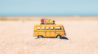 Toy bus on a beach, going on holiday