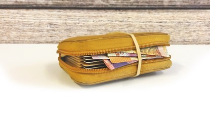 Rubber band around cash inside a wallet