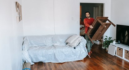 Man carrying table into lounge