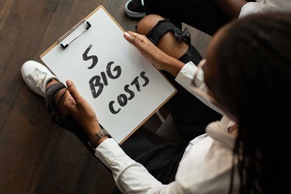 Person holding clipboard with text saying "5 big costs"