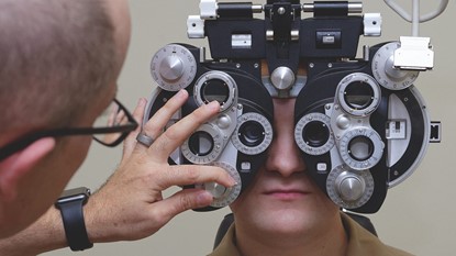 Optometrist correcting patient's eyes