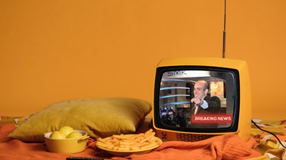 Retro television and food sitting on a bed