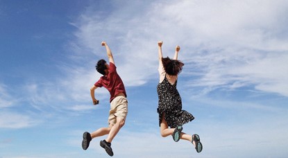 Two people jumping in the air in excitement
