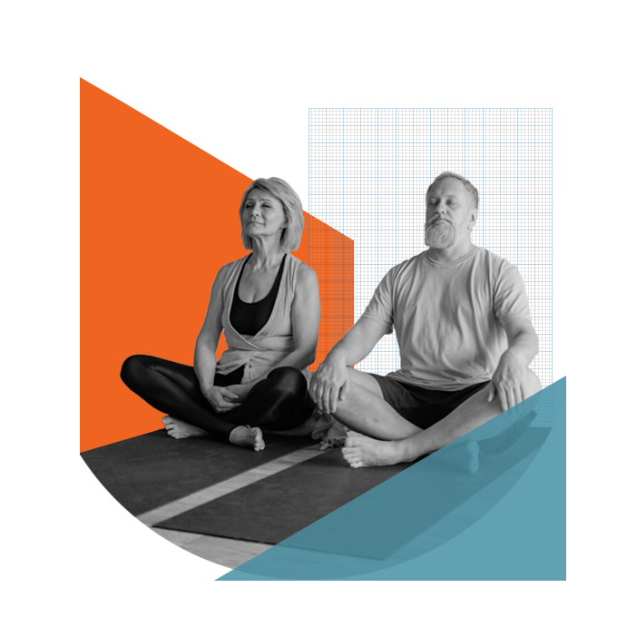 Middle aged couple sitting relaxed on yoga mats