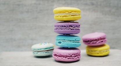 Three stacks of different coloured macaroons sitting next to each other.