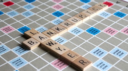 Scrabble board with the words "lawyer" played top to bottom overlapping with the word "bankruptcy" played left to right.
